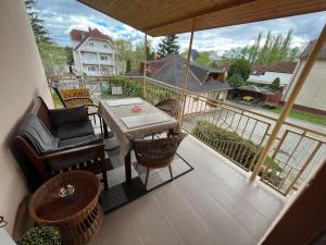 a balcony with a table and chairs on a patio at RELAX13 Vendégház in Hévíz