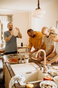 eine Gruppe von Menschen, die in einer Küche stehen und Pizza kochen in der Unterkunft Odpoczywalnia Pakosław in Pakosław