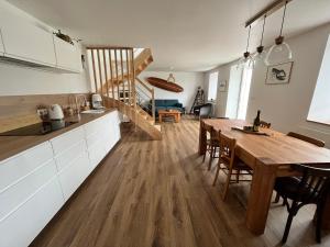 eine Küche und ein Esszimmer mit einem Holztisch in der Unterkunft Kelerdutbay fr, accès direct à la mer in Plouguerneau