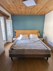 a bedroom with a large bed with a wooden ceiling at La maison du 146 in Flavin