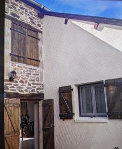 a white building with wooden doors and windows at La maison du 146 in Flavin +4 photos