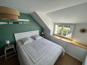 ein Schlafzimmer mit einem weißen Bett und einem Fenster in der Unterkunft Kelerdutbay fr, accès direct à la mer in Plouguerneau
