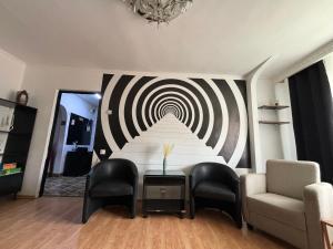 ein Wohnzimmer mit einem Tisch und einem Wandspiralbild in der Unterkunft Hypnotic Suite Pitesti in Piteşti