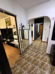 ein Wohnzimmer mit einem großen Spiegel und Fliesenboden in der Unterkunft Hypnotic Suite Pitesti in Piteşti