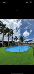 a large blue swimming pool with palm trees in the background at Royal View Residence in Meerzorg