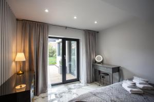 a bedroom with a bed and a desk and a window at Luxury Redcar Seaside Retreat in Redcar
