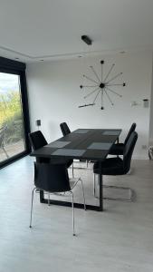 un tavolo da pranzo nero con sedie in camera di Schillerhöhe Luxury-Hideout - Traumblick mit viel Platz und Privatsphäre a Gerlingen