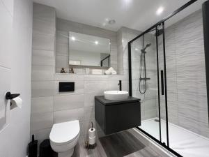 a bathroom with a toilet and a sink and a shower at The Seven Suites Liverpool in Liverpool