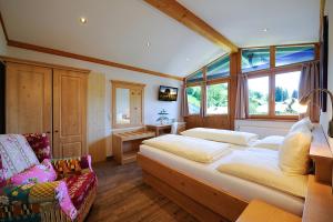 a bedroom with a large bed and a chair at Sportpension Goldegg in Goldegg