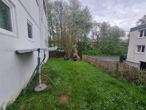 einen Hof neben einem Haus mit einem Zaun in der Unterkunft Ferienwohnung/Apartment Siegen in Siegen