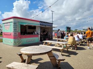 a food truck with tables and people standing around it at Remarkable 5-Bed Cabin in Clacton-on-Sea in Clacton-on-Sea