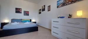 a bedroom with a bed and a dresser at Una finestra sul Golfo di Le Grazie in Le Grazie
