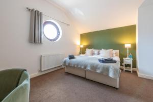 a bedroom with a large bed with a window at Brook Farm Barn in Frodsham