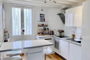 a white kitchen with a mask on the wall at Magnificent house of 90 m with private pool in Talence