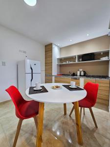 a kitchen with a white table and two red chairs at Posadas Fratelli in Salta +35 photos