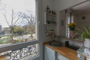 una cucina con lavandino e finestra di Cozy two-room apartment in Montreuil a Montreuil