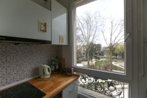 una cucina con finestra affacciata su una strada di Cozy two-room apartment in Montreuil a Montreuil
