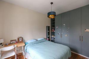 una camera con letto e scrivania di Cozy two-room apartment in Montreuil a Montreuil