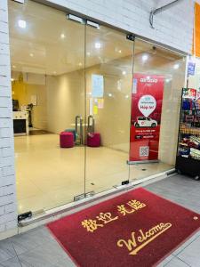une fenêtre avec un tapis rouge de bienvenue dans un magasin dans l'établissement Swing & Pillows - Kajang, à Kajang