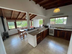 a large kitchen with wooden cabinets and a counter top at Cabañas el Bierzo in Villa Cura Brochero