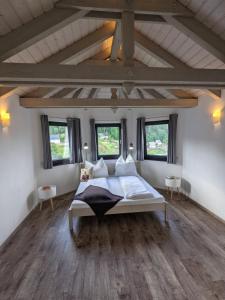 ein Schlafzimmer mit einem großen Bett in einem Zimmer mit Fenstern in der Unterkunft Ferienwohnung Mühl - einfach wohlfühlen in Marienberg