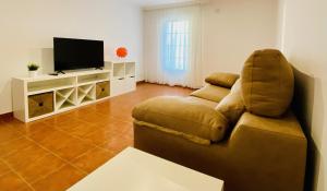 a living room with a couch and a television at LA CASITA DE MANOLI in Chillarón de Cuenca