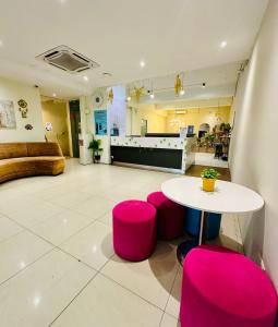 Duży pokój ze stołem i różowymi stołkami w obiekcie Swing & Pillows - Kajang Selangor w mieście Kajang