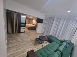 a living room with a green couch and a table at Donau Resort in Eşelniţa