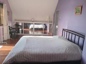 una camera con un grande letto al centro di una stanza di Sue's Place a Paramaribo