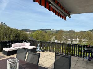 a patio with a couch and chairs on a balcony at Eifel Ferienwohnung Thiel in Oberstadtfeld