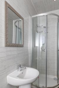 a white bathroom with a sink and a shower at Central Apartment Darlington in Darlington