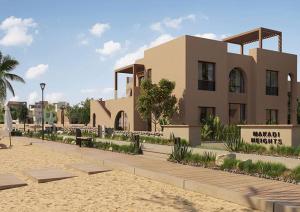 a building on a beach next to a sandy beach at Cozy Chalet in Makadi Heights in Hurghada