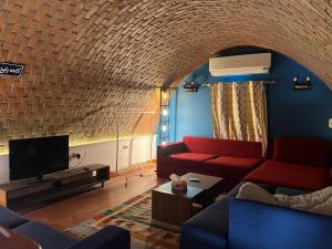 a living room with a couch and a tv at Cozy Chalet in Makadi Heights in Hurghada