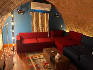 a living room with a red couch and a brick wall at Cozy Chalet in Makadi Heights in Hurghada