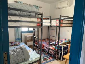 a room with three bunk beds in a room at Cozy Chalet in Makadi Heights in Hurghada