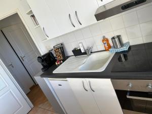 una cucina con lavandino e armadietti bianchi di Appartement Evreux a Évreux