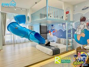 um quarto infantil com um escorrega insuflável azul em Bali Residence Melaka By Heystay Management em Malaca