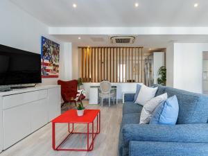 sala de estar con sofá azul y mesa roja en GRAND LOFT LUXE place Masséna Liberté, en Niza