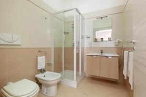 a bathroom with a toilet and a shower and a sink at La Conchiglia sul mare Hotel in San Vito lo Capo