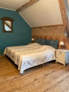 a bedroom with a large bed and a wooden floor at Les Fruits du Passau in Saint-Désiré