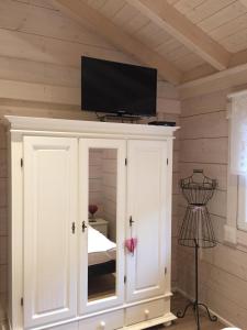 a tv on top of a white cabinet in a room at Blockhaus Edelweiss in Rieden