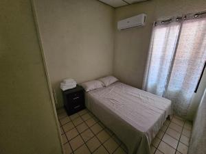 a small bedroom with a bed and a window at Buena Vista Home in Nueva San Salvador