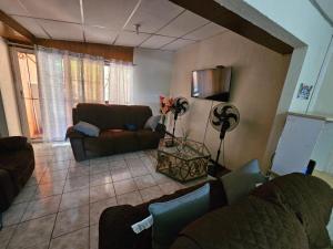 a living room with a couch and a fan at Buena Vista Home in Nueva San Salvador