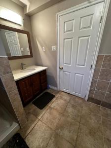 a bathroom with a sink and a white door at Budget Stay in Kitchener- Near Town Centre- Food, Shopping, Transit in Kitchener