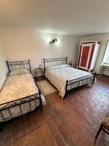 two beds in a room with two windows at Casa Garibaldi in Pontremoli