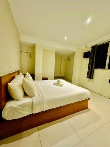 - une chambre dotée d'un grand lit avec des draps et des oreillers blancs dans l'établissement Swing & Pillows - Kajang, à Kajang