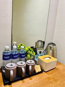 a tray with bottles of water and a mirror at Swing & Pillows - Kajang in Kajang
