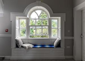 an arch window with a bench in a room at Mountrothe House in Kilkenny