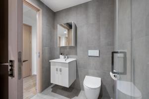 a bathroom with a toilet and a sink and a mirror at Modern 1BR Flat in the Heart of Milton Keynes in Milton Keynes