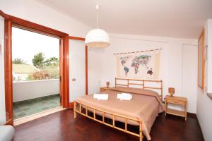 una camera da letto con un letto e una grande finestra di Casa Sciusca a Cefalù